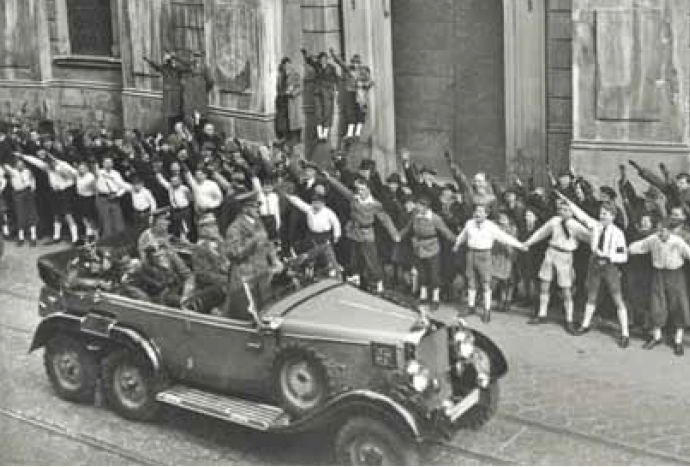13. März 1938: Im offenen Fahrzeug lässt sich Adolf Hitler über die
Landstraße chauffieren und von der Bevölkerung frenetisch feiern.