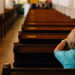 senior woman praying at a pew in church